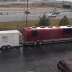 The "Mobile Studio USA" trailer is seen attached to a large maroon tour bus belonging to the band Pentatonix, parked in a lot. The trailer setup indicates it’s ready to support audio recording needs on the road.